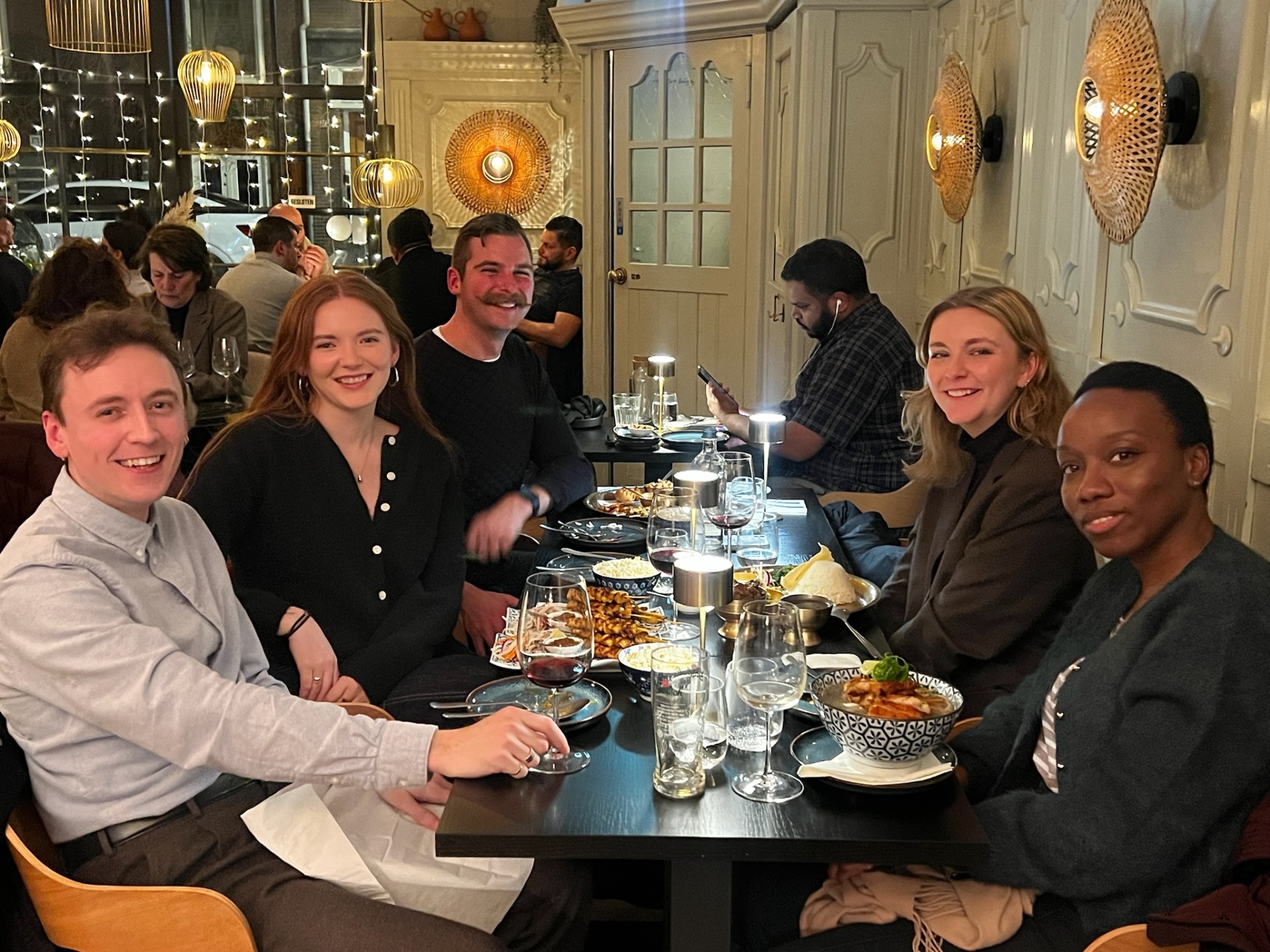 Guests sharing plates and wine at Yuzu Dining Bar in Amsterdam